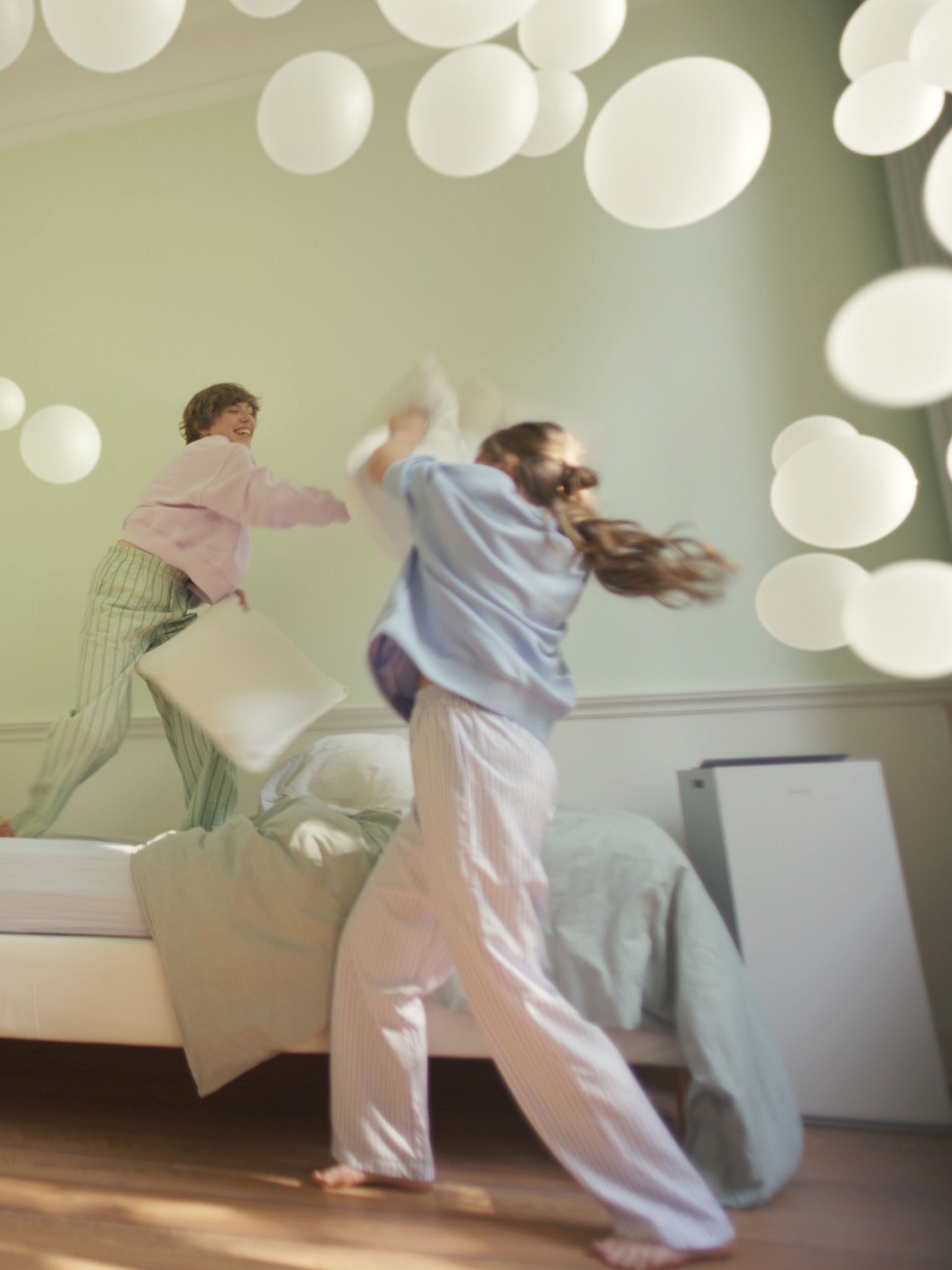 Zwei Mädchen spielen in einem Schlafzimmer mit gut geregelter Luftfeuchtigkeit, unterstützt durch einen DAIKIN Luftreiniger
