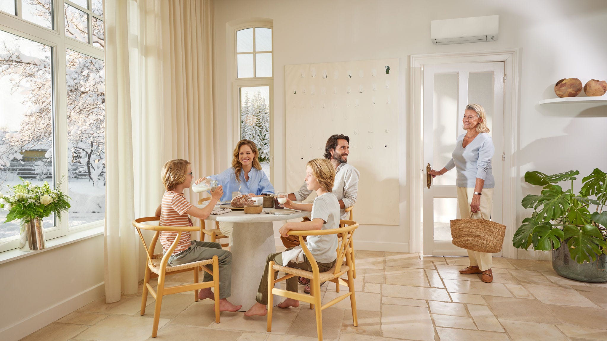 Eine Familie entspannt sich im Wohnzimmer und genießt den Komfort und die Kühle einer DAIKIN Komfortlösung
