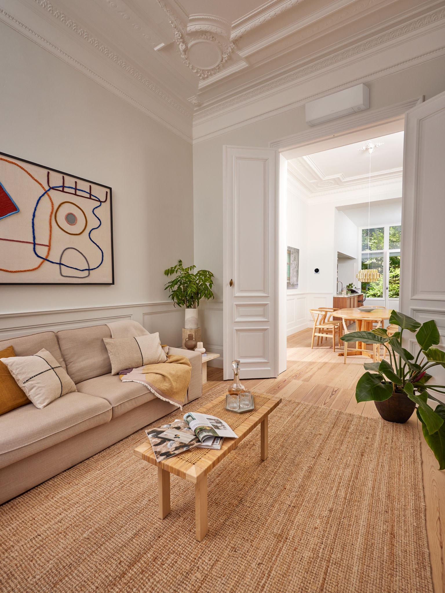 Elegantes Wohnzimmer, ausgestattet mit einem Wärmepumpengerät über einer Tür. Das verdeutlicht, wie Wärmepumpen dank staatlicher Förderprogramme immer besser zugänglich für Heizen und Kühlen von Wohnräumen werden