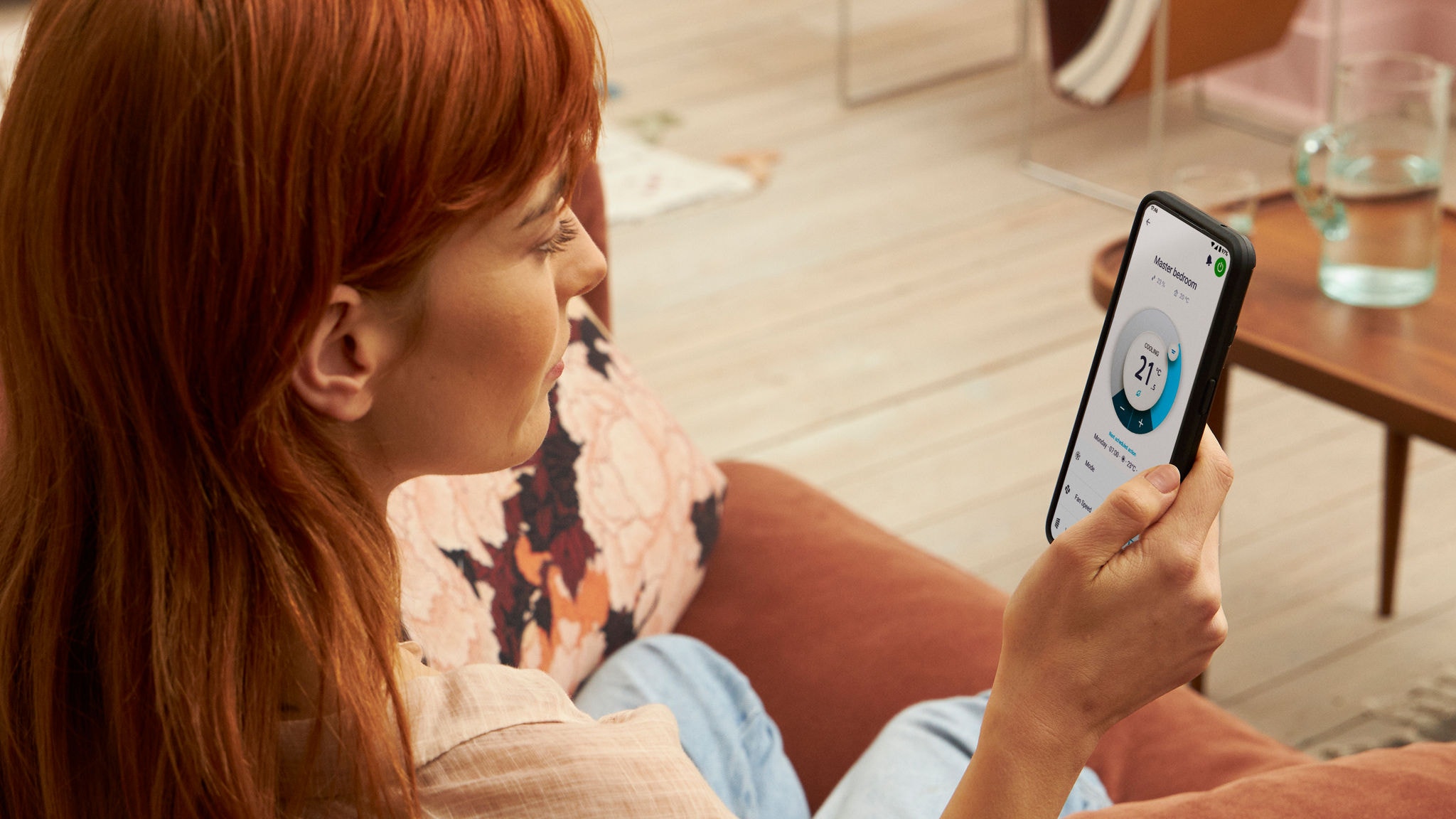 Eine Frau nutzt die Onecta-App, um die Heizung zu überprüfen