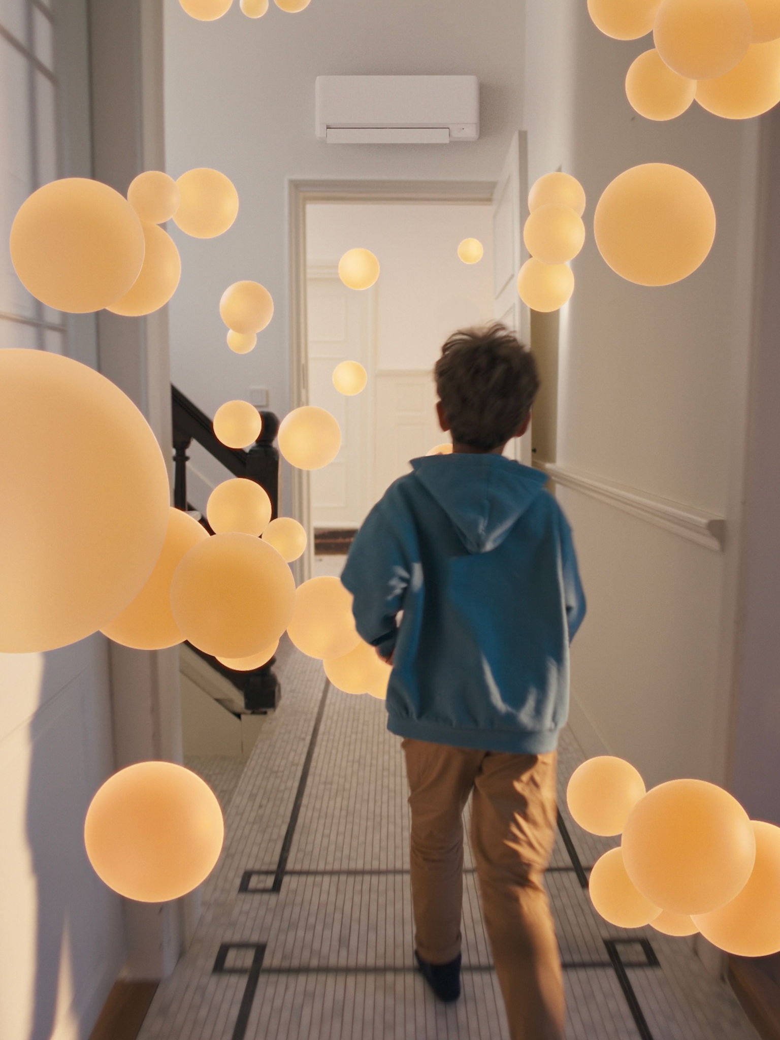 Junge geht durch einen Hausflur mit gleichmäßigem, wohltemperiertem Luftstrom, ermöglicht durch ein gut konzipiertes Luft-Luft-Wärmepumpensystem