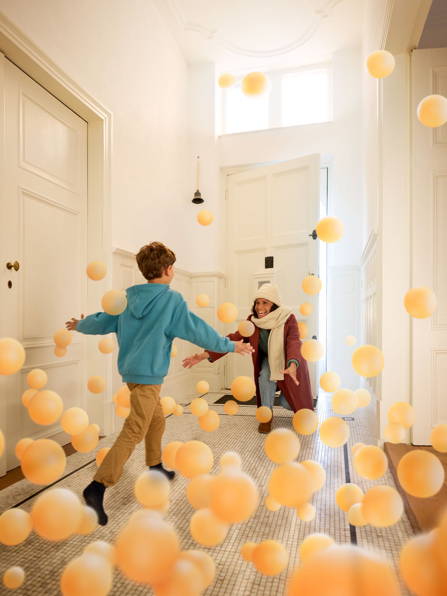 Sohn umarmt seine Mutter in einem einladenden Hausflur. Das steht für Komfort, Wärme und unsichtbare Wirkung der dank DAIKIN sauberer, perfekt klimatisierter Raumluft.