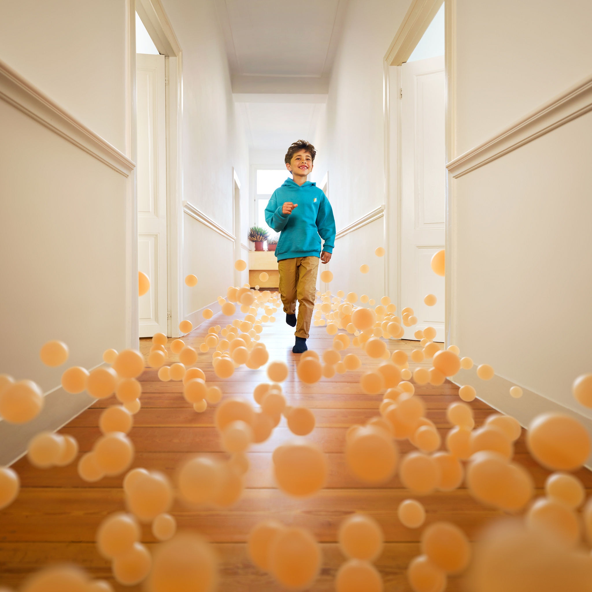 Junge rennt durch einen dank Luft-Wasser-Wärmepumpe perfekt klimatisierten Hausflur