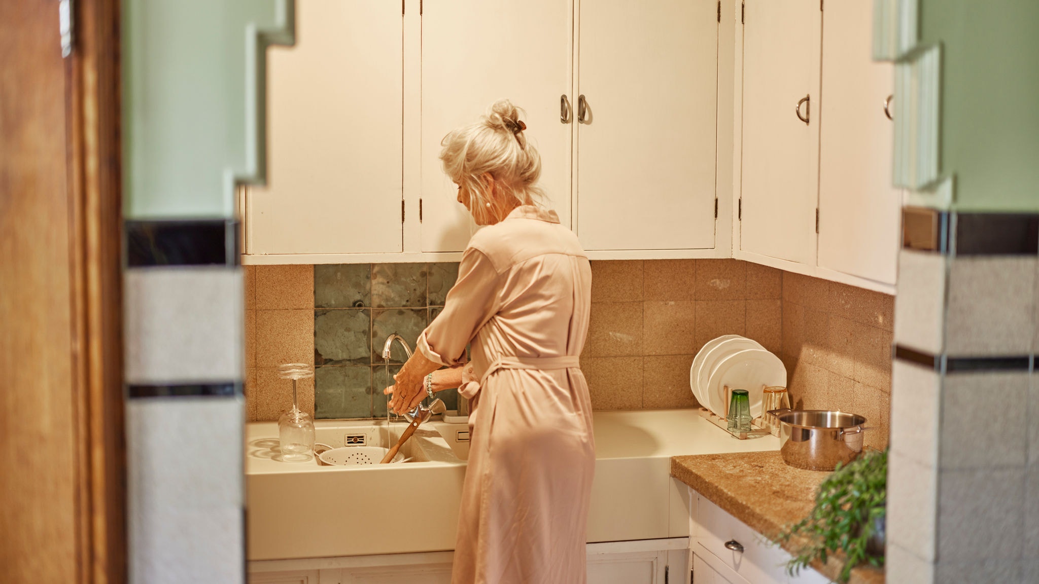 Frau beim Geschirrspülen mit warmem Wasser von einem Multisplit-System