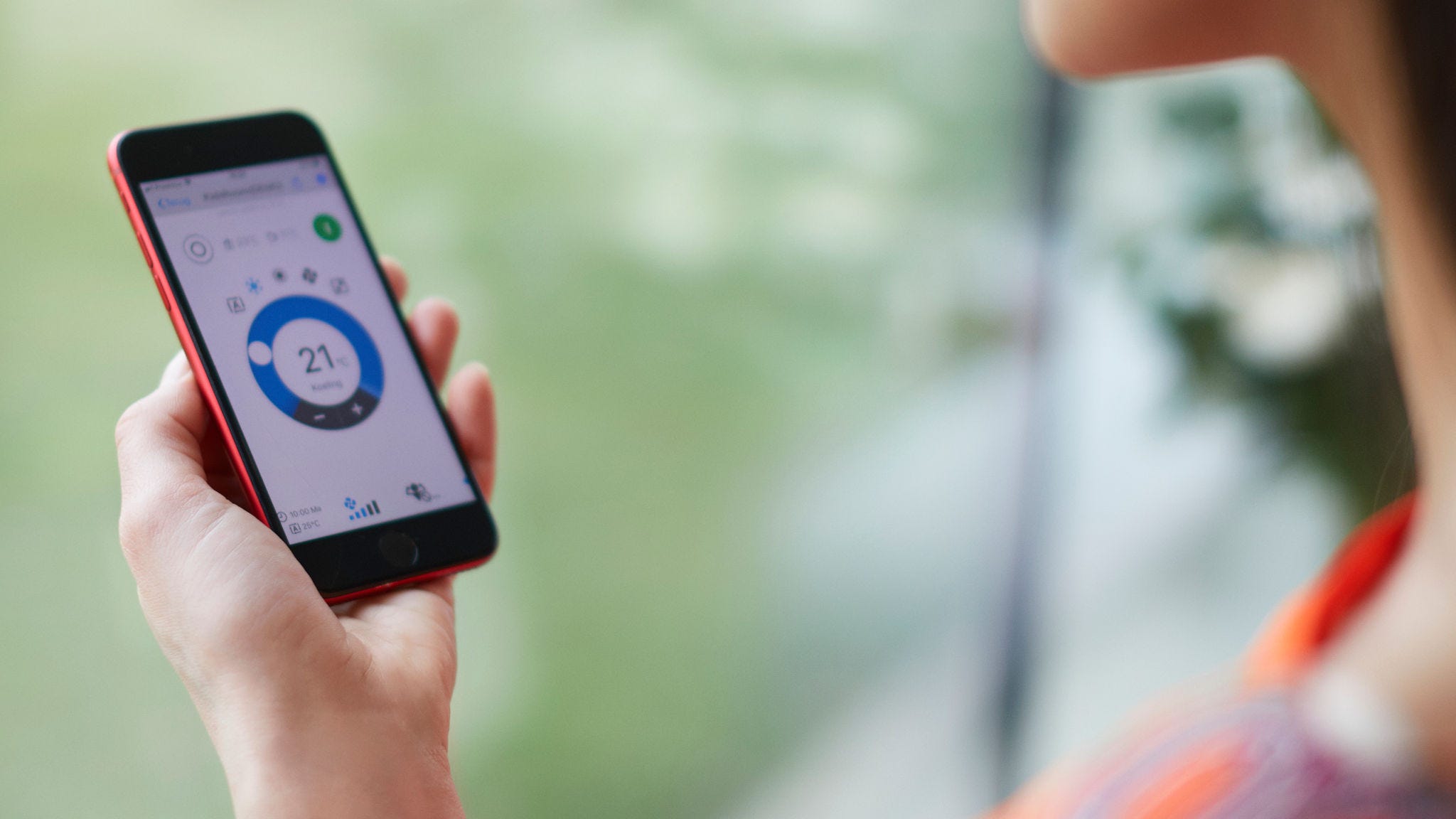 Eine Frau bedient ihr Heizsystem via App