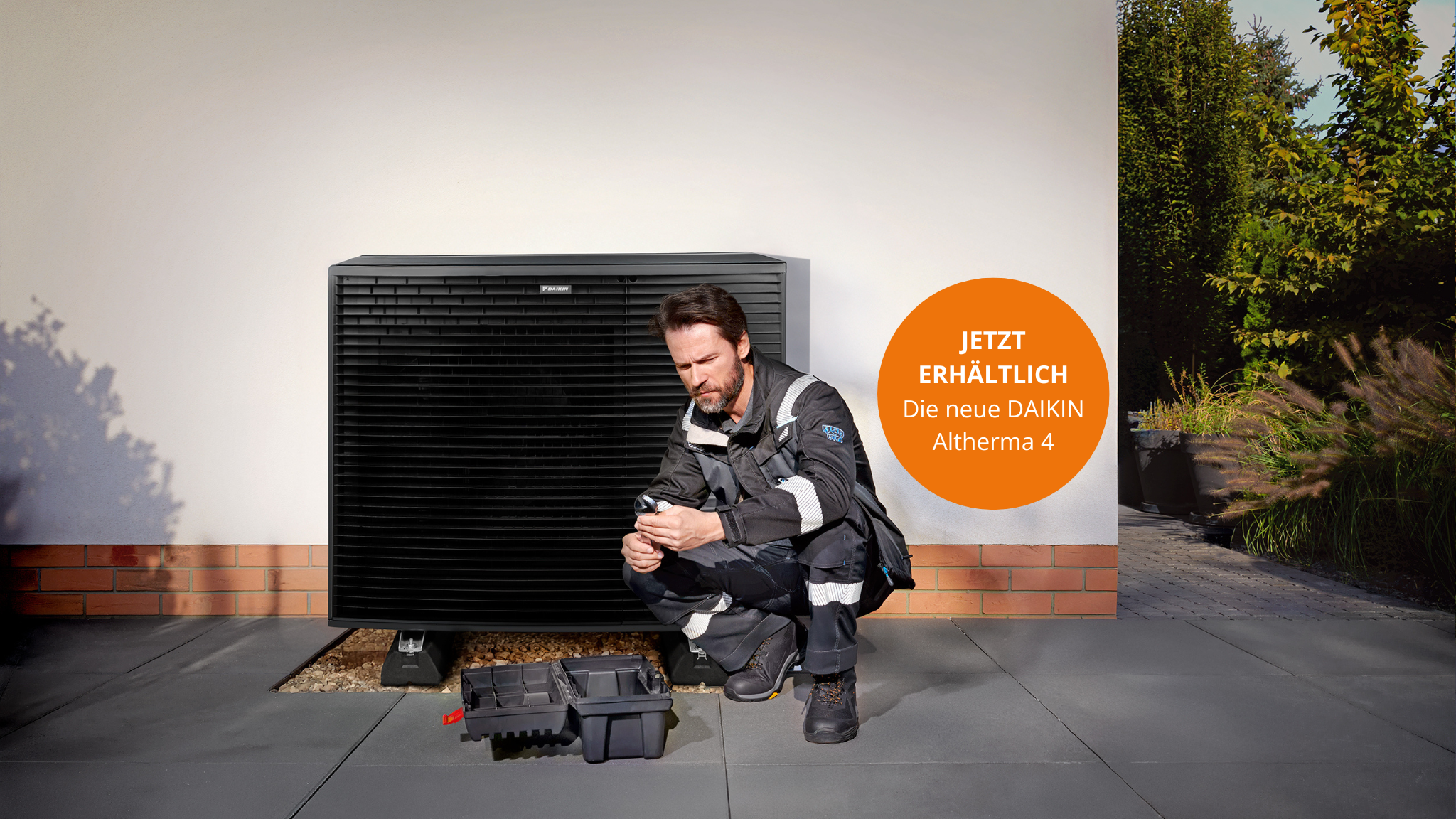 Ein Paar im Gespräch mit einem Fachbetrieb im Garten neben einem DAIKIN Altherma-Außengerät