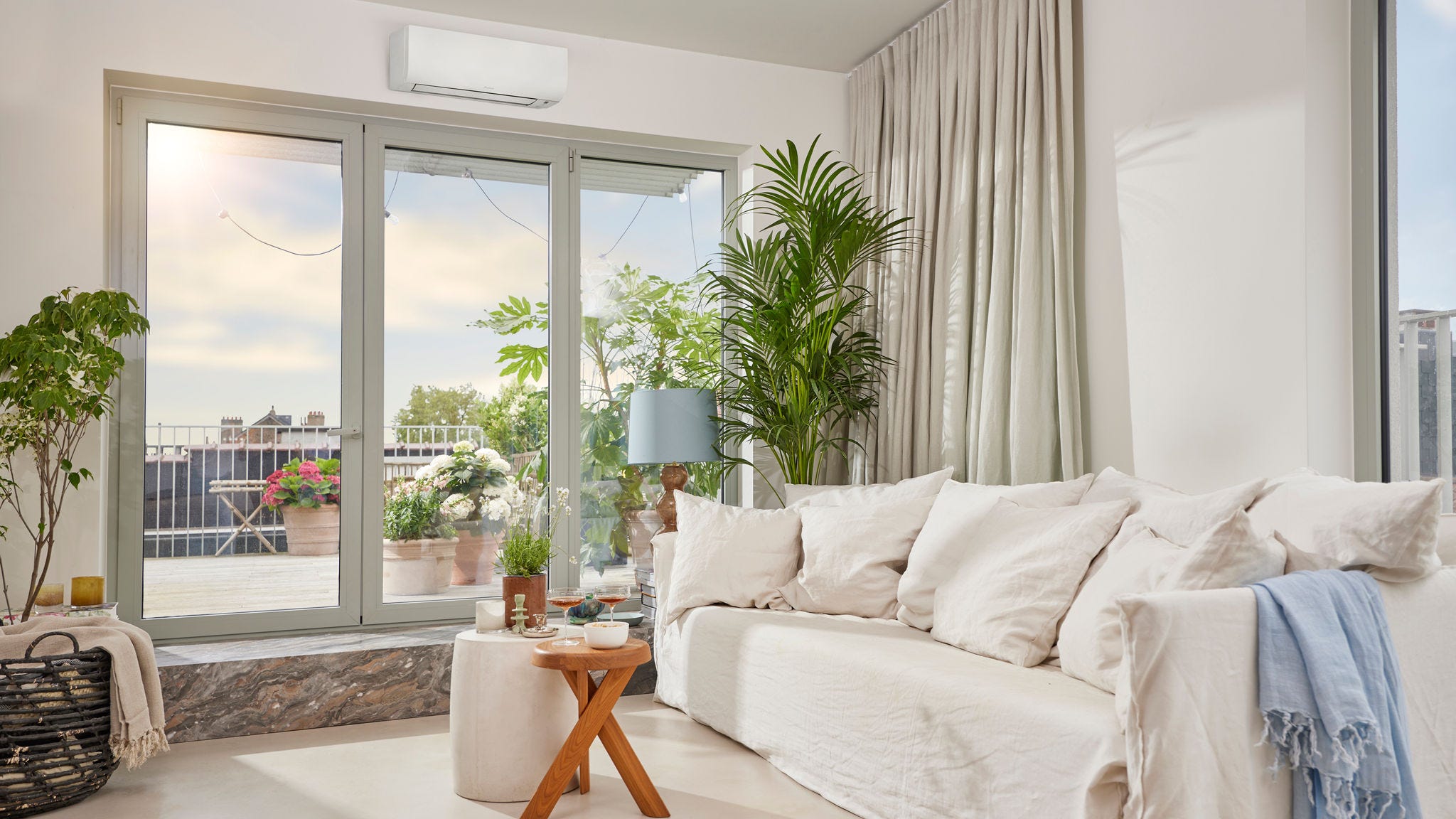 Ein heller, luftiger Raum mit einem unauffälligen, weißen Wandgerät einer Luft-Luft-Wärmepumpe für Heizen und Kühlen