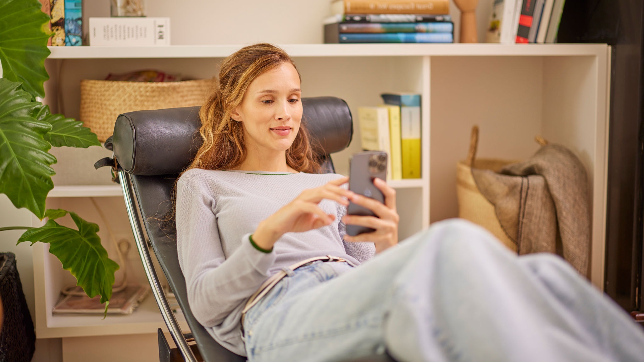 Hausbesitzerin regelt ihren Luftreiniger mit der Onecta App, um die Luft im Haus zu reinigen.