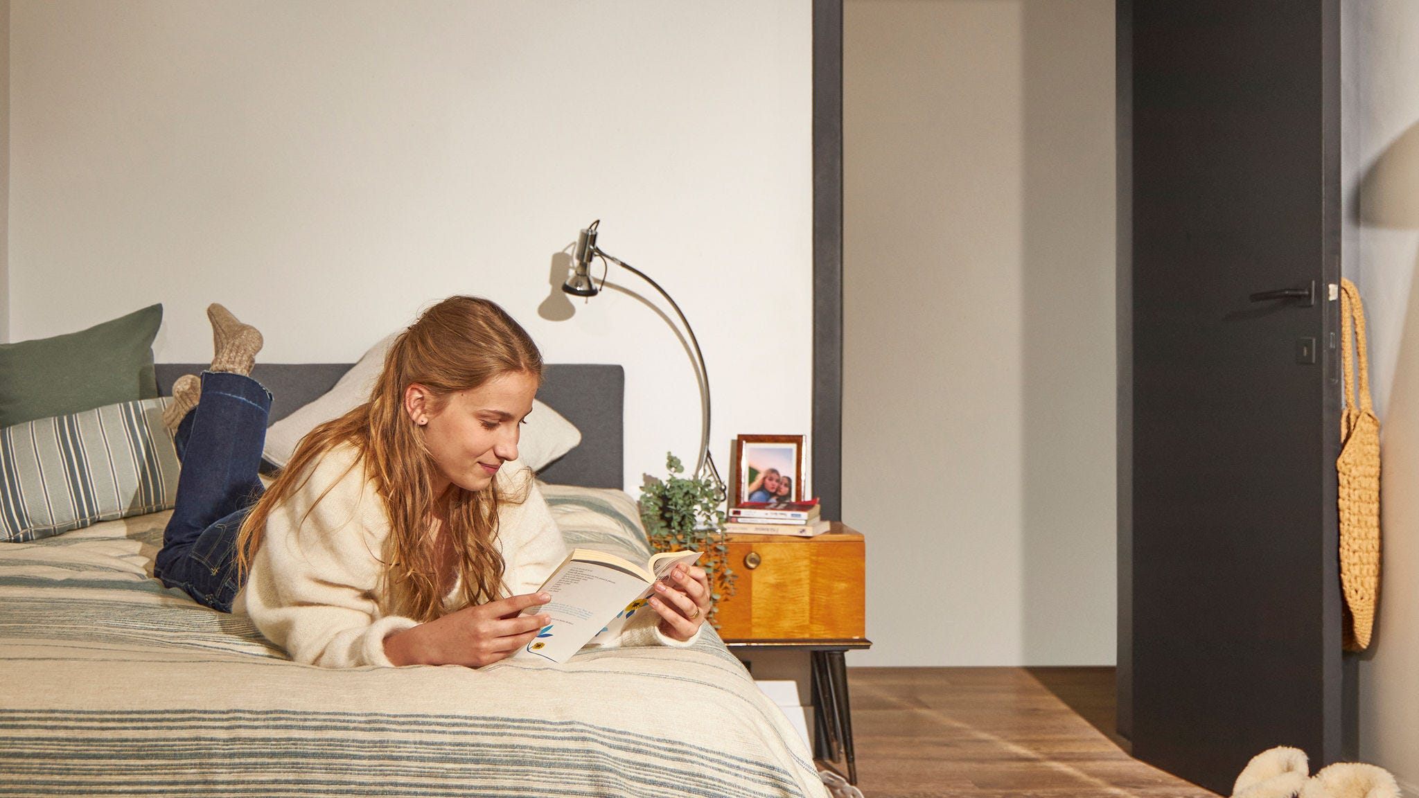 Frau, die sich auf dem Bett entspannt, in einem ruhigen Zuhause mit einer schallarmen Wärmepumpe