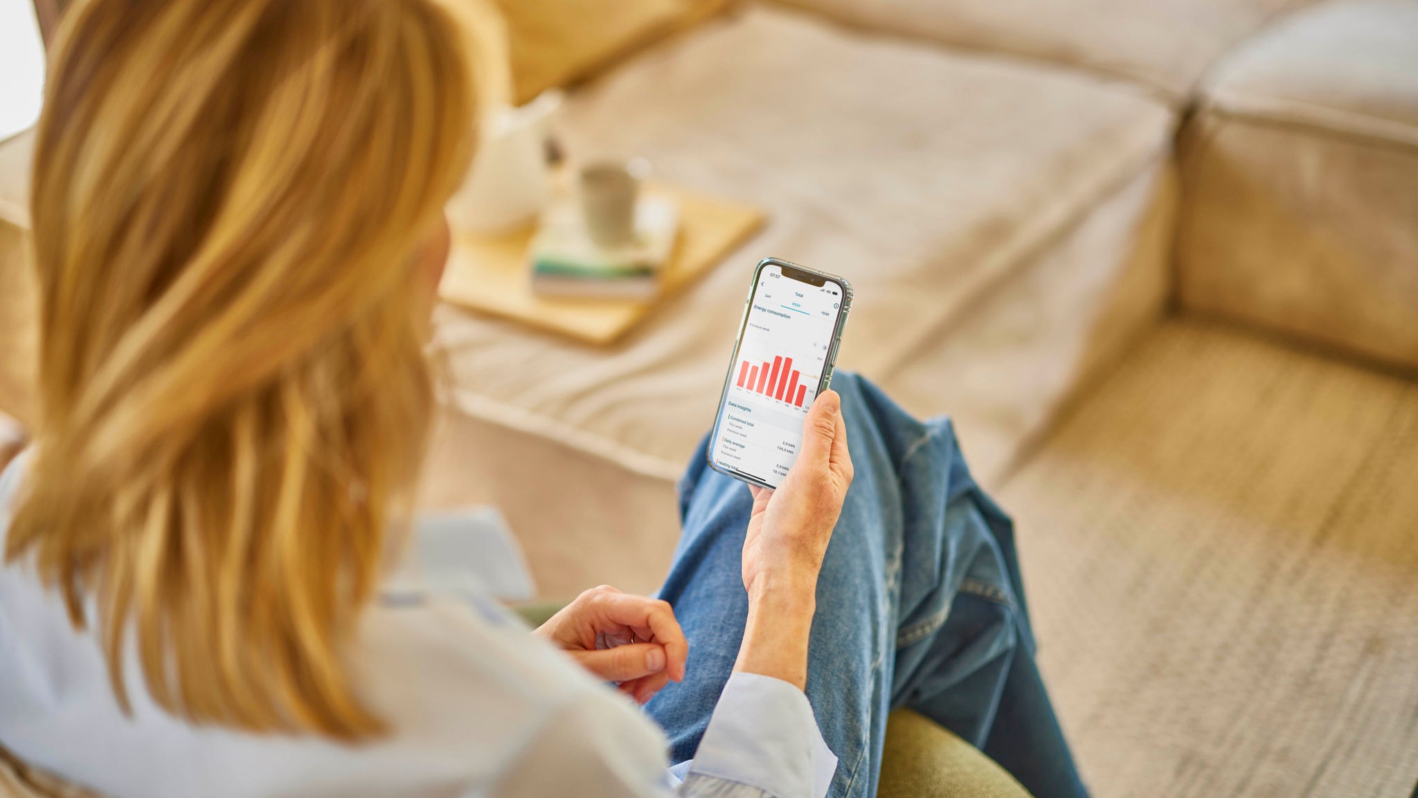 Frau bedient ihr Lüftungsgerät anhand der Onecta-App