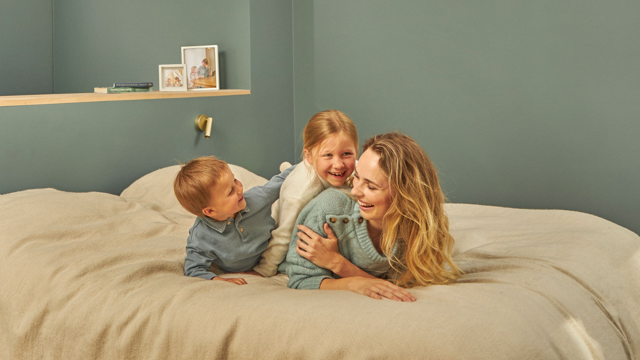 Eine Mutter spielt mit ihren Kindern im Bett