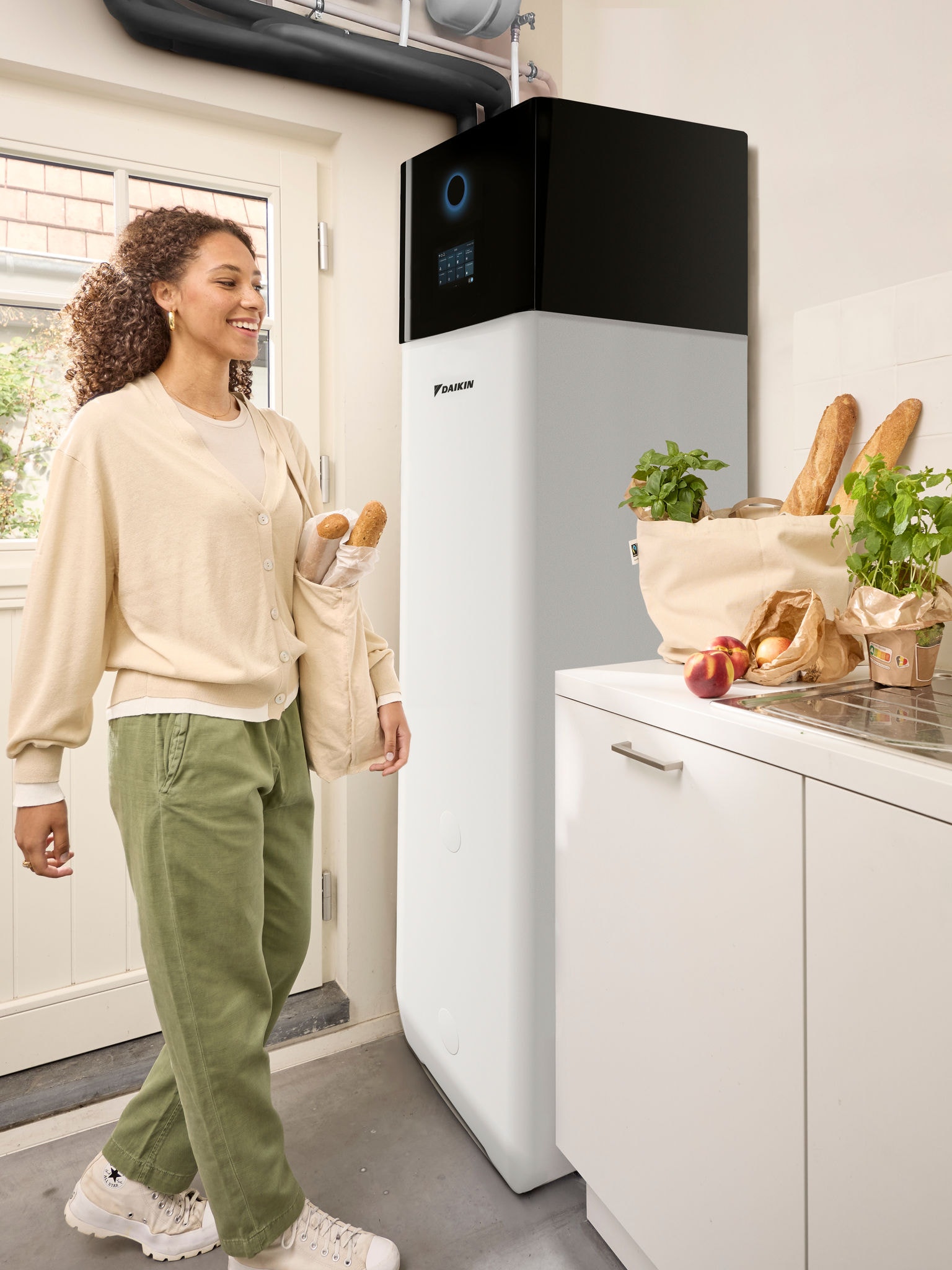 Eine vom Einkauf nachhause kommende Frau trägt Tüten mit Lebensmitteln