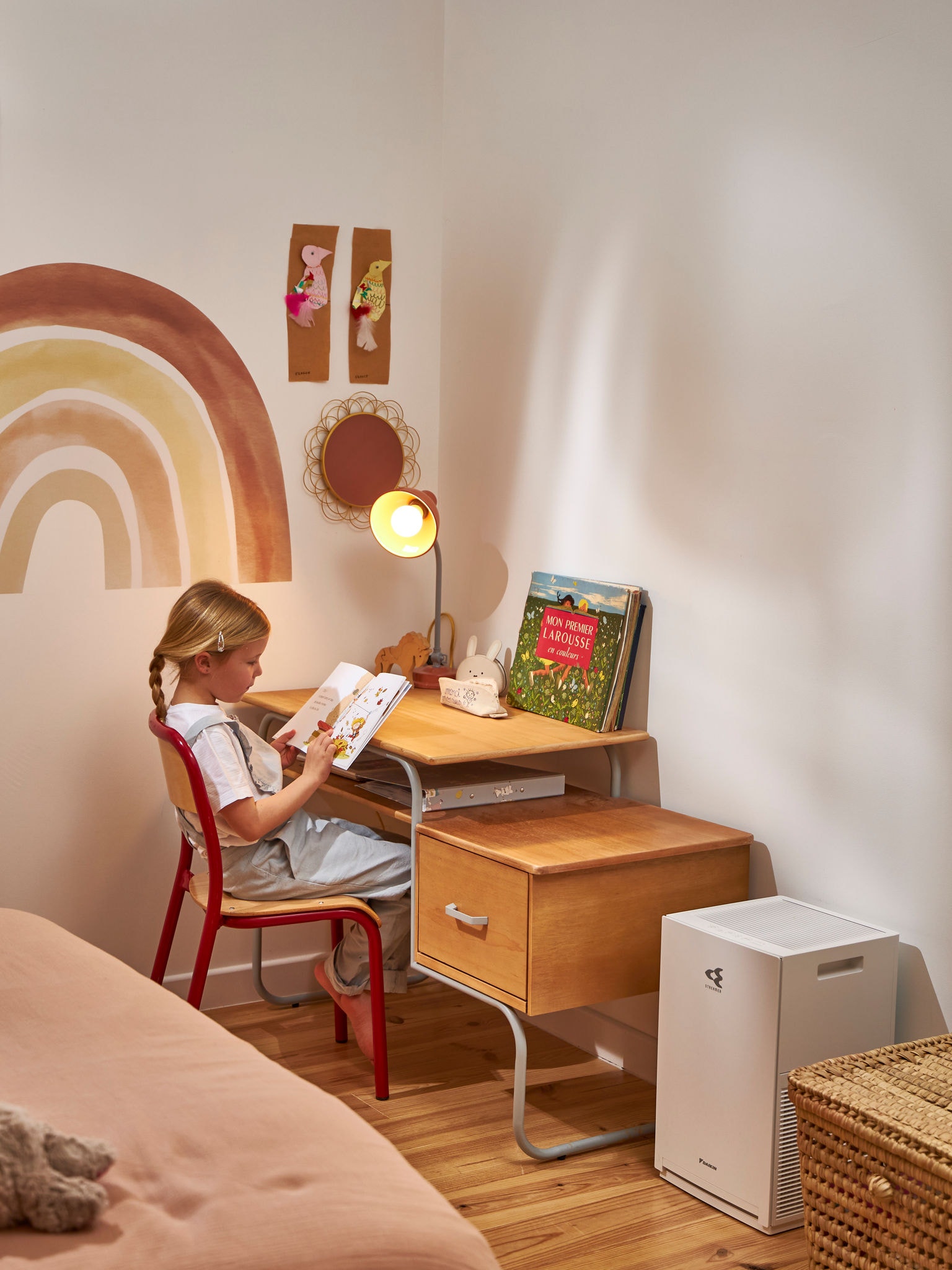 Ein Kind liest neben einem Luftreiniger