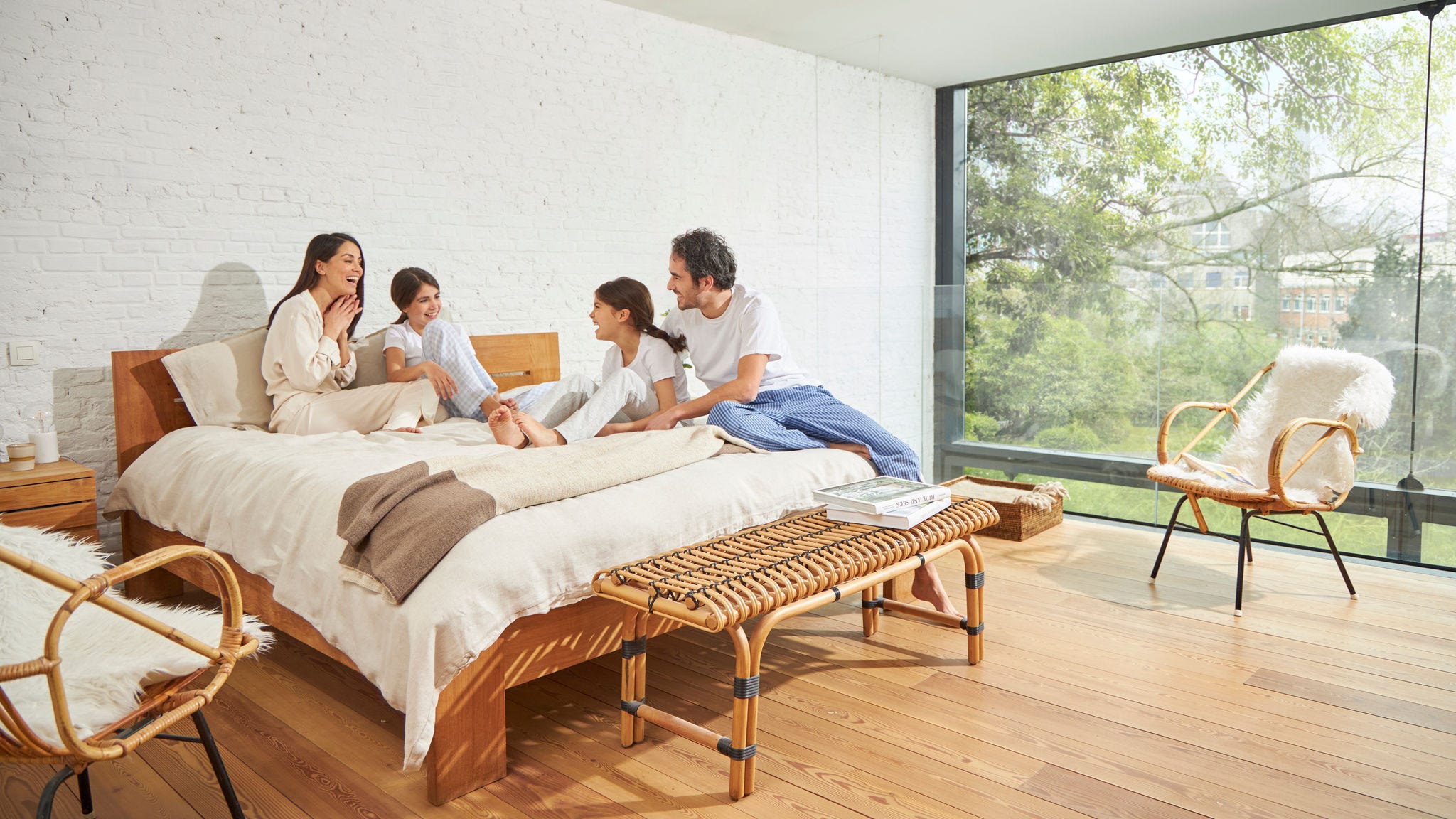 Vierköpfige Familie genießt die von einem Lüftungssystem erzeugte frische Luft im Wohnzimmer