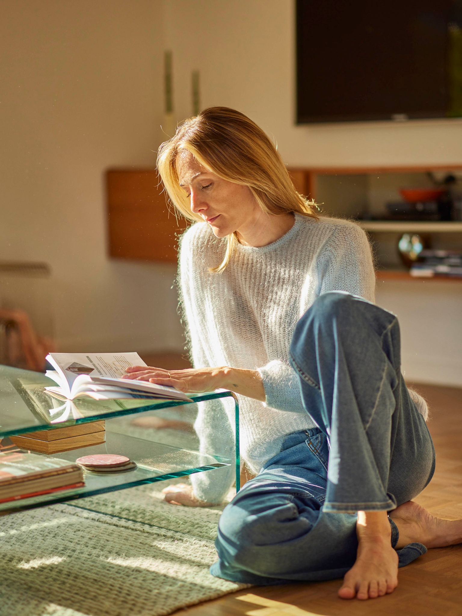 Frau mit einem Buch entspannt sich in einem energieeffizienten Haus, geheizt von einer Wärmepumpe