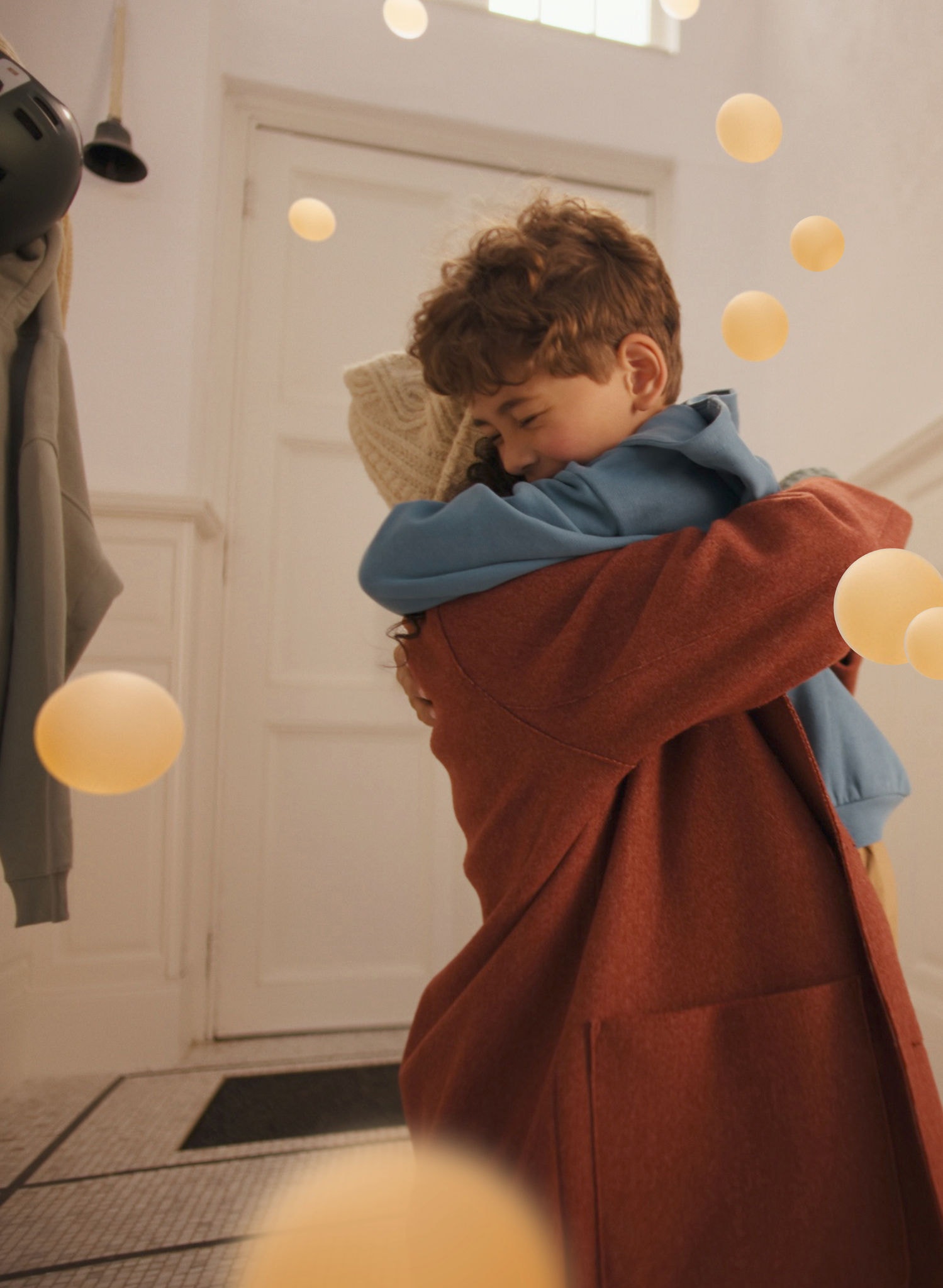 Mutter und Sohn umarmen sich in einem stilvollen, ruhigen Wohnbereich und genießen den flüsterleisen Komfort einer DAIKIN Luft-Luft-Wärmepumpe