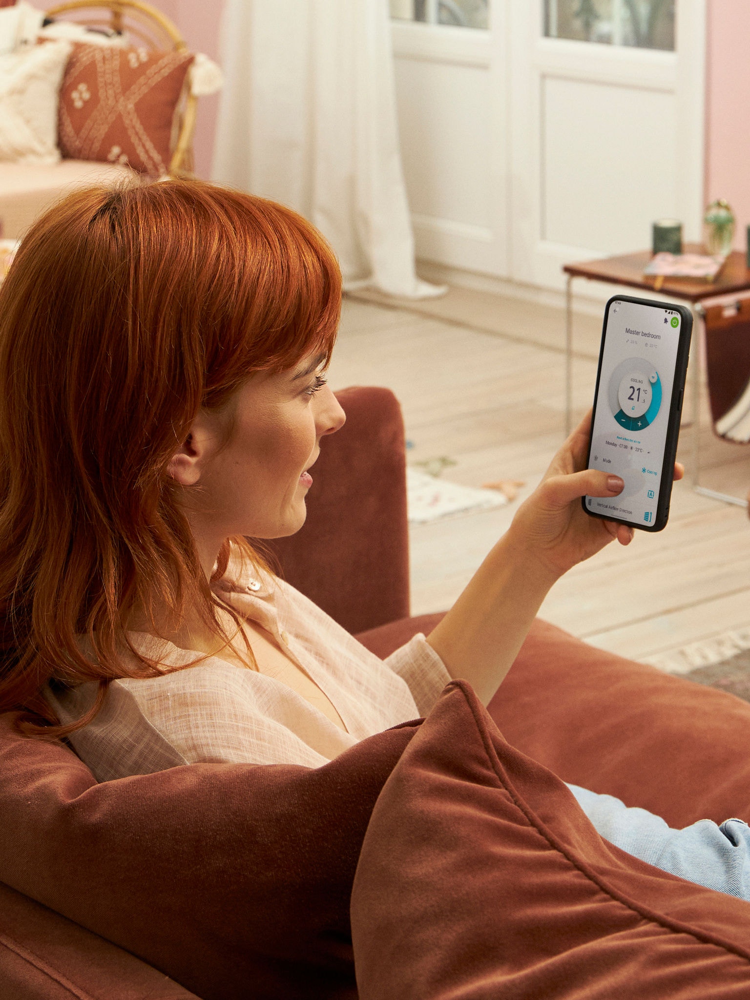 Eine Dame bedient in der Onecta App auf ihrem Smartphone die einzelnen Innengeräte unabhängig voneinander