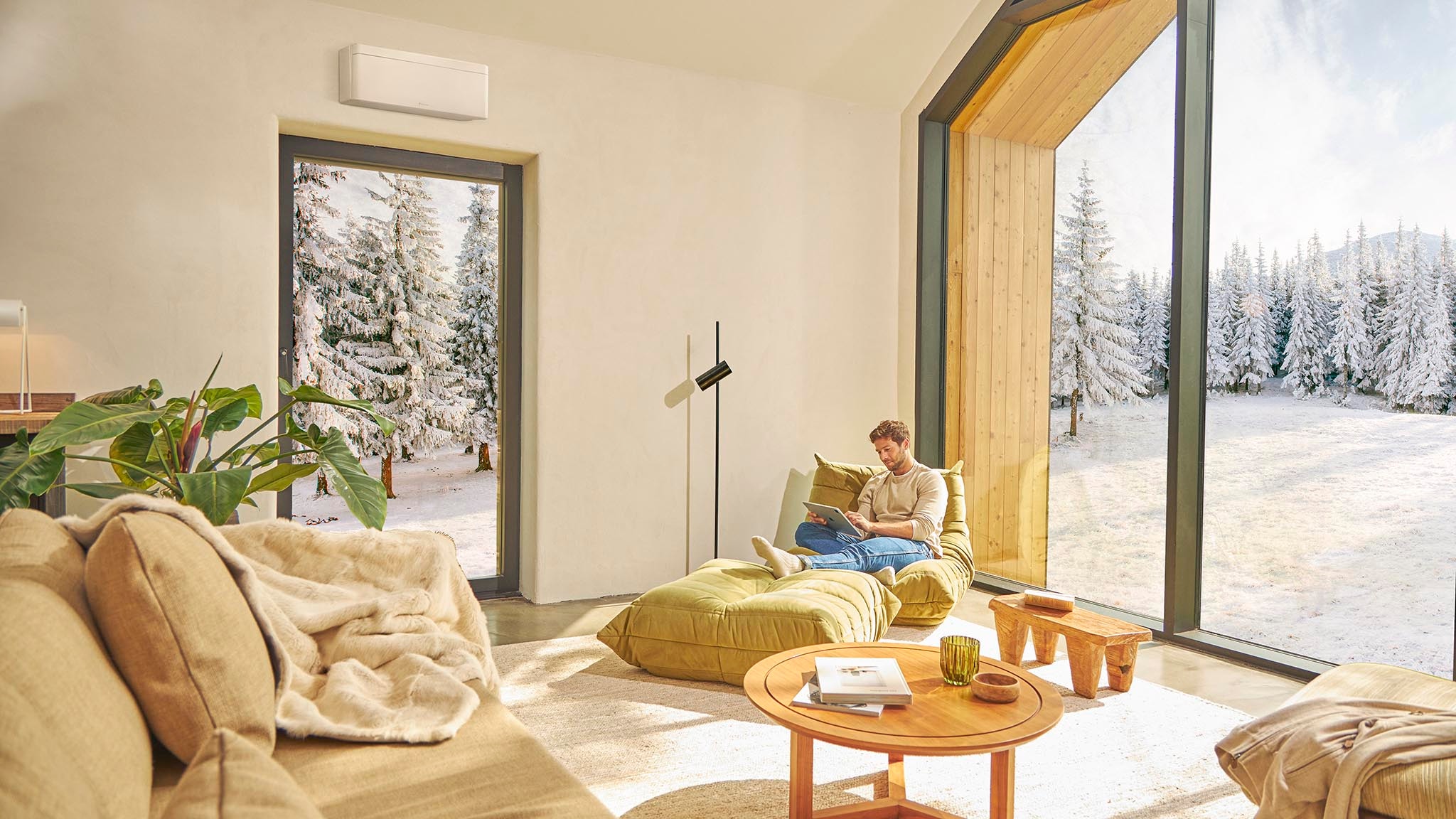 Ein Mann sitzt auf der Couch und genießt die Wärme der Klimaanlage