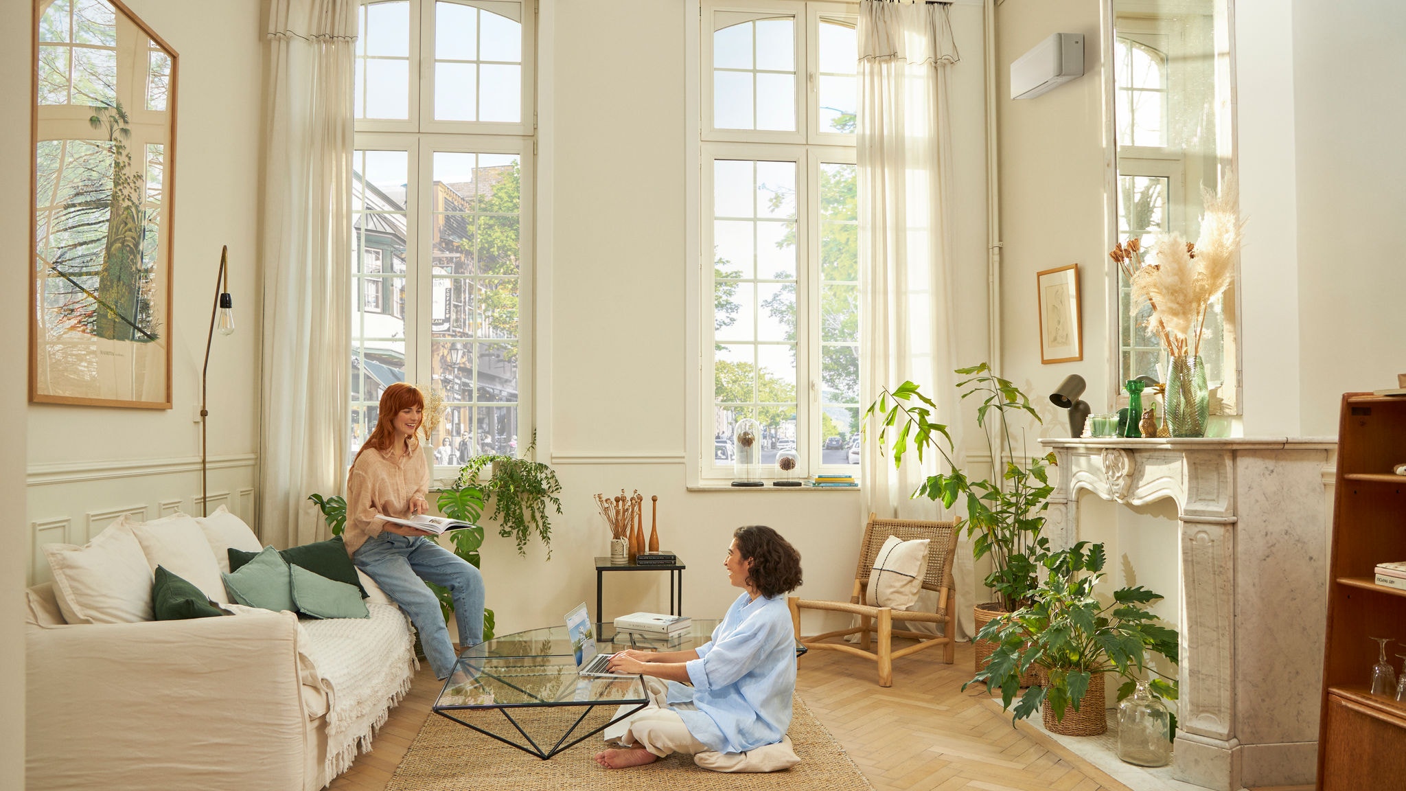 Eine Frau sitzt im Wohnzimmer, dank der DAIKIN Luft-Luft-Wärmepumpe hat sie eine gemütliche Atmosphäre